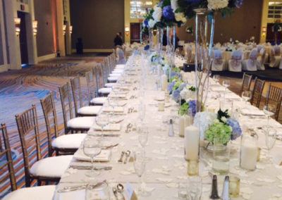 Specialty linen on long banquet tables with gold chivari chairs