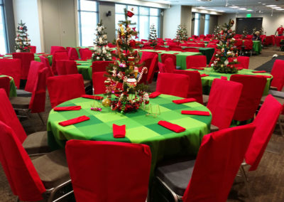 Green plaid linens on round tables with red chair covers