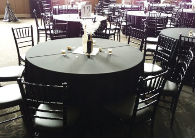Dark linens on round tables with black chivari chairs