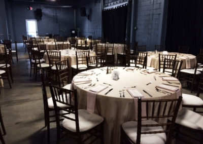 Light linens on round tables with fruitwood chivari chairs