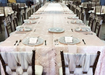 Pink lace specialty linen on banquet tables with woven ribbon chairs
