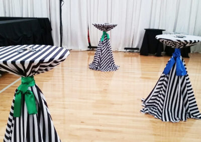 Striped linens on cocktail tables tied with blue and green ribbons