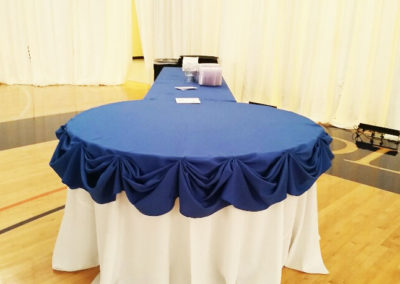 Blue linens with white skirting on banquet tables