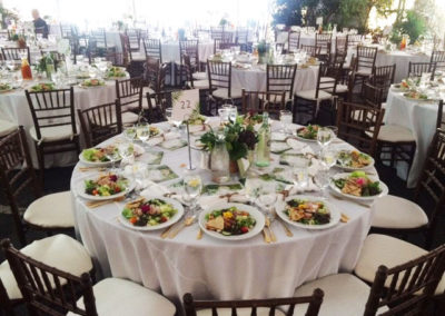 White linens on round tables with fruitwood chivari chairs