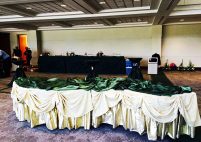 Green and gold serpentine tables for corporate event