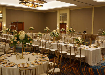 White linens on banquet tables with gold chivari chairs
