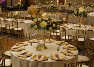 White linens on round tables with gold chivari chairs