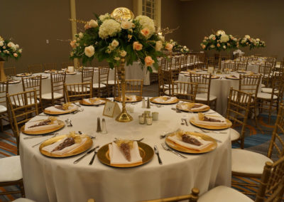 White linens on round tables with gold chivari chairs