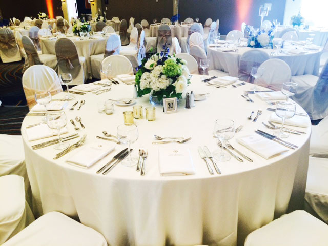 All white linens on round table with white chair covers