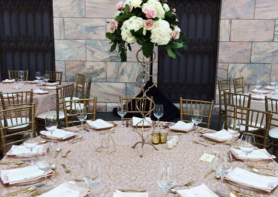 Light pink specialty linens on round tables with gold chivari chairs