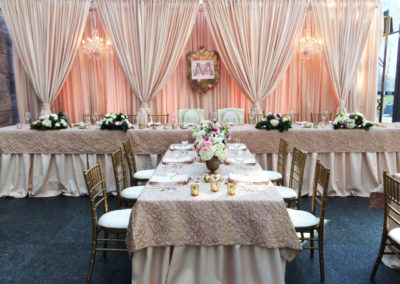 Light pink draping behind head table at wedding reception