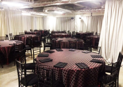 Patterned specialty linen on round table with black chivari chairs