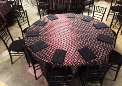 Patterned specialty linen on round table with black chivari chairs