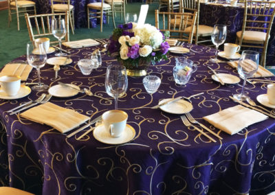 Purple and gold specialty linen on round table