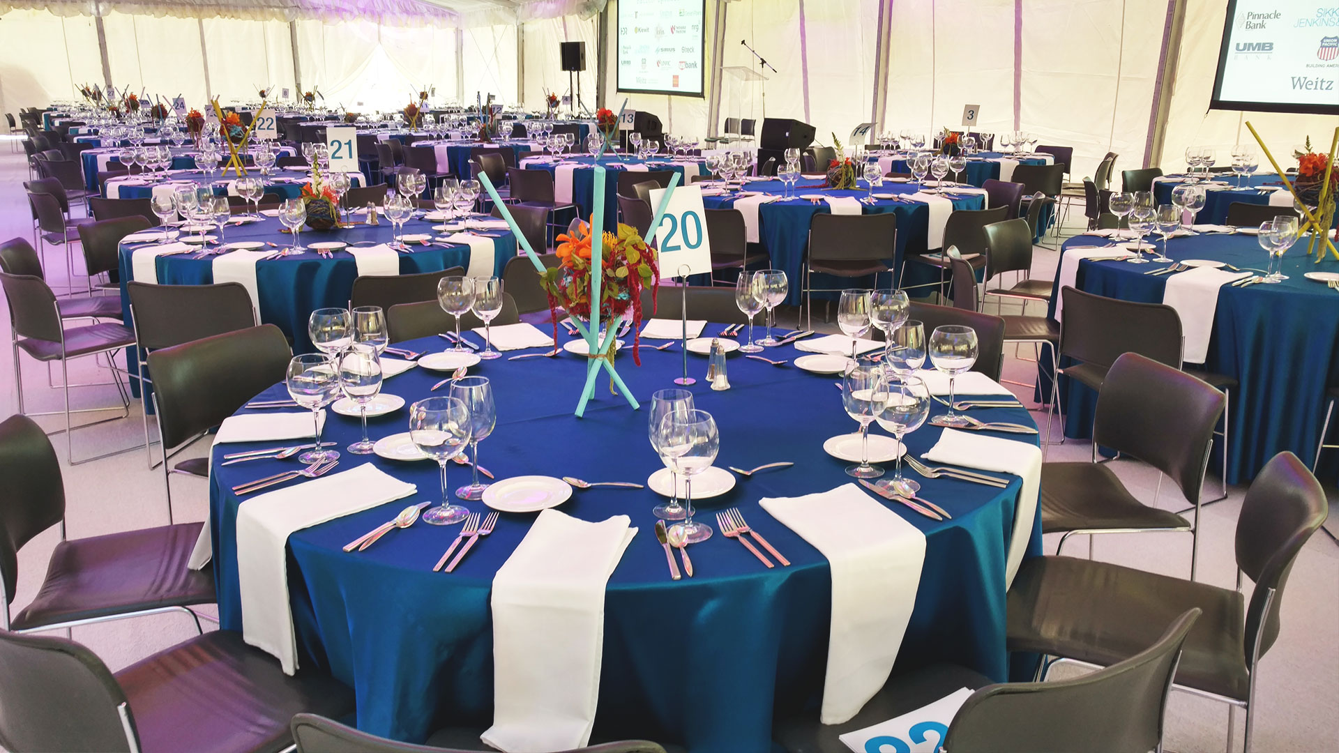 Blue linens on round tables for corporate event