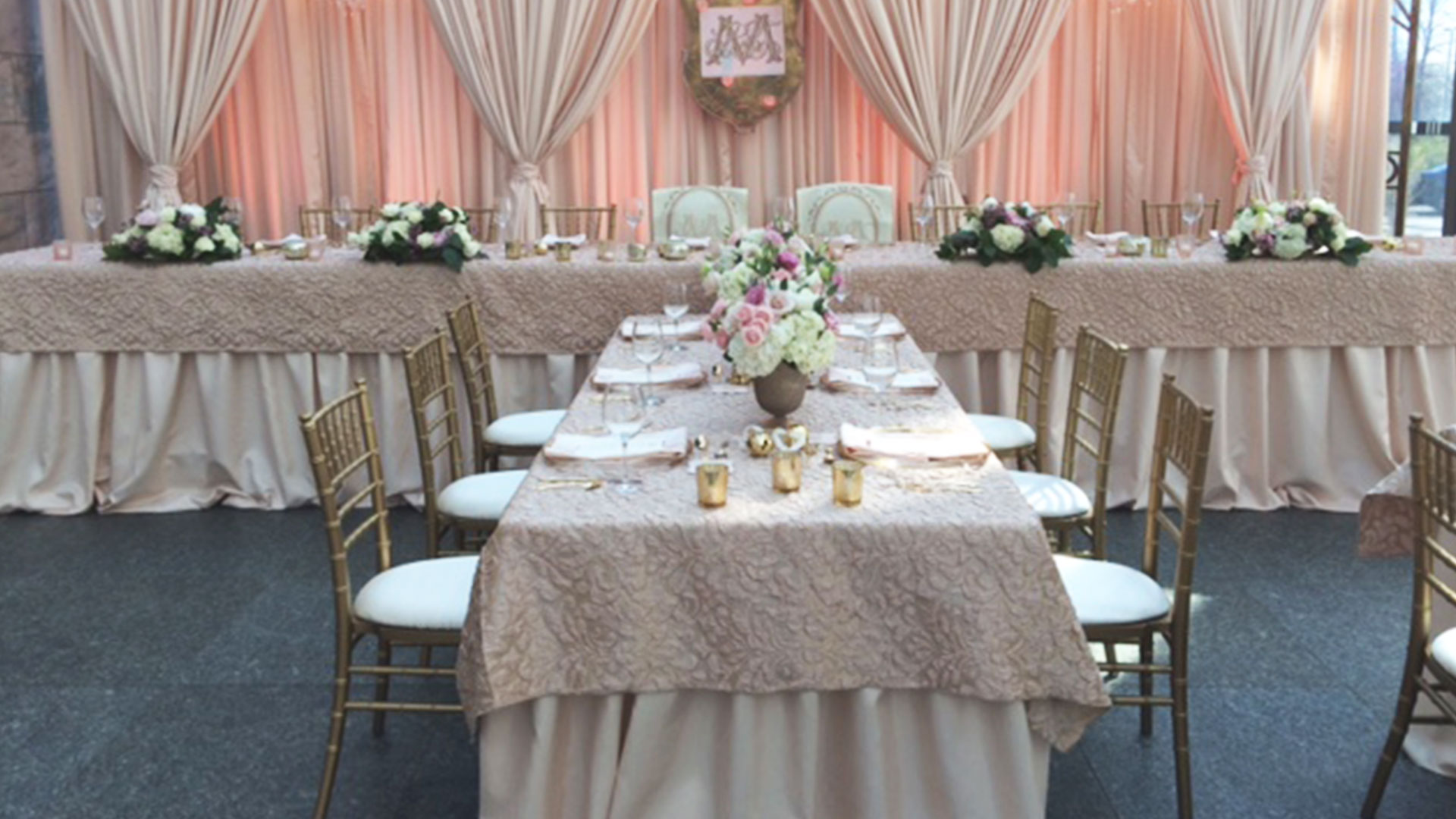 Pink specialty linens with gold chivari chairs and draping for wedding reception